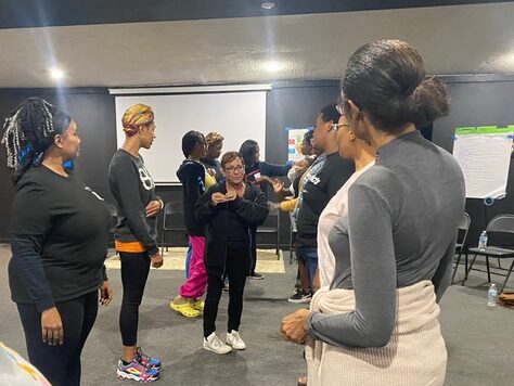 Self-defense teacher instructing a class of black women