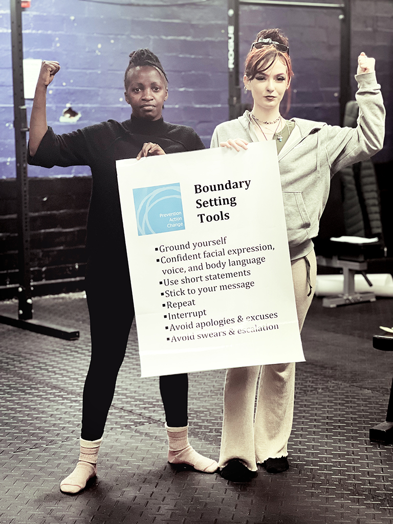 two women holding up a poster 